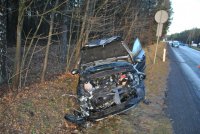 Na zdjęciu widać samochód marki Ford Focus, który znajduje się w przydrożnym rowie. Auto ma rozbity przód,  podniesioną do góry maskę widać silnik i inne uszkodzone elementy.