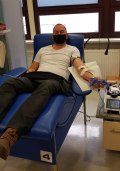 Na zdjęciu widać asp. szt. Michała Dzierkę. Policjant siedzi na fotelu i oddaje osocze.