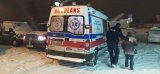 Na zdjęciu widać policjanta, który idzie z seniorką i pomaga jej dotrzeć do ambulansu