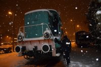 Na zdjęciu widać policjanta, który sprawdza, czy osoby bezdomne śpią w lokomotywie.