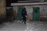 Na zdjęciu widać policjanta, który sprawdza teren przy szopach