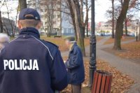 Na zdjęciu widać odwróconego tyłem policjanta, przed którym stoi starszy mężczyzna