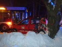 Na zdjęciu widać bok uszkodzonego samochodu osobowego, przed którym widać bok autobusu.