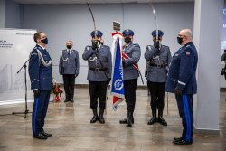 Zdjęcie kolorowe. Na fotografii widać od lewej inspektora Romana Rabsztyna, poczet sztandarowy oraz nadinspektora Krzysztofa Justyńskiego