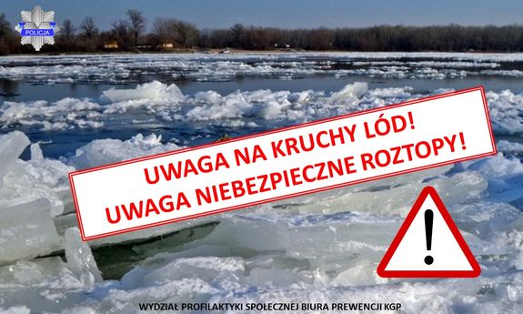 widok rzeki z kawałkami kry i lodu w oddali drzewa i budynki mieszkalne.  Na środku zdjecia napis UWAGA NA KRUCHY LÓD, UWAGA NIEBEZPIECZNE ROZTOPY.