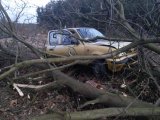 Na zdjęciu widać samochód osobowy marki Nissan Micra, który wjechał w przydrożne krzaki