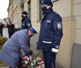 Komendant Bylicki kładzie znicz pod pamiątkową tablicą