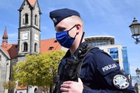 Na zdjęciu widać policjanta z maseczką na twarzy