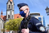 Na zdjęciu widać policjanta z maseczką na twarzy