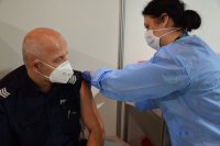 Na zdjęciu widać policjanta, któremu pielęgniarka robi zastrzyk.