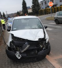 Na zdjęciu widać zaparkowany na poboczu drogi samochód marki Fiat Panda. Auto ma uszkodzony przód. Za samochodem stoi policyjny radiowóz, obok którego stoi policjant.