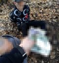 Na zdjęciu widać zatrzymanego mężczyznę siedzącego z zapiętymi kajdankami na ziemi.