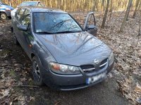 Na zdjęciu widać nissana zaparkowanego w leśnej uliczce. Za samochodem widać policyjny radiowóz oraz radiowóz nieoznakowany.