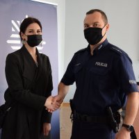 kobieta ściska rękę dzielnicowemu