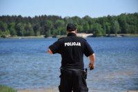 Na fotografii widać policjanta, który obserwuje akwen