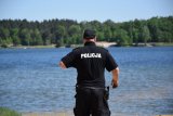Na fotografii widać policjanta, który obserwuje akwen