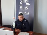 Na zdjęciu widać policyjnego profilaktyka, który prowadzi prelekcję online.