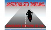 Motocyklista na jezdni, u góry napis: Motocyklisto zwolnij, poniżej jednośladem bezpiecznie do celu. U dołu grafiki napis: Biuro Ruchu Drogowego Komendy Głównej Policji oraz policyjna gwiazda i logo ruchu drogowego.