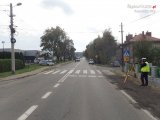 Na zdjęciu widać przejście dla pieszych w rejonie skrzyżowania. Po jednej stronie ulicy widać policyjny radiowóz, a po drugiej stronie policjanta.