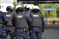 Na zdjęciu widać policjantów z oddziałów prewencji ubranych w białe hełmy i osłony
