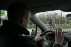 Na zdjęciu widać mężczyznę siedzącego za kierownicą samochodu.