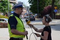 Na zdjęciu widać policjanta, który udziela wywiadu dziennikarce z Radia Piekary