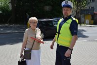 Na zdjęciu widać policjanta oraz seniorkę. Kobieta pokazuje odblask, który otrzymała od policjanta.
