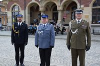 Na zdjęciu widać Komendanta Powiatowego Policji w Tarnowskich Górach młodszego inspektora Sławomira Bylickiego oraz przedstawicieli wojska i straży pożarnej. Mundurowi stoją na płycie Rynku w Tarnowskich Górach.