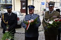 Na zdjęciu widać Komendanta Powiatowego Policji w Tarnowskich Górach młodszego inspektora Sławomira Bylickiego oraz przedstawicieli wojska i straży pożarnej. Mundurowi trzymają w dłoniach wiązanki kwiatów.