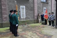 Na zdjęciu widać tablicę upamiętniającą „Poległych Powstańców Ziemi Tarnogórskiej”, obok której stoją przedstawiciele Kurkowego Bractwa Strzeleckiego w Tarnowskich Górach.