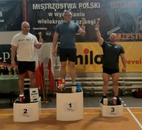 Na zdjęciu widać stojącego na pierwszym miejscu podium dzielnicowego aspiranta sztabowego Ryszarda Prega, który w dłoni trzyma puchar. Obok policjanta, na niższych miejscach podium stoją jego konkurenci.
