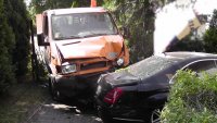 Na zdjęciu widać samochód iveco, który przebił ogrodzenie i uderzył zaparkowanego na posesji mercedesa