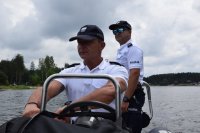 Na zdjęciu widać policjantów na łodzi motorowej płynącej po zalewie Nakło-Chechło.