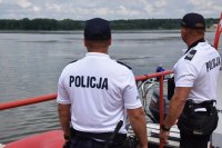 Na zdjęciu widać policjantów stojących na pomoście i obserwujących zalew Nakło-Chechło.