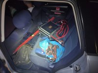 Na zdjęciu widać elektronarzędzia, kable oraz inne przedmioty ułożone na tylnej kanapie samochodu