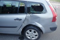 Na zdjęciu widać bok samochodu biorącego udział w zdarzeniu. Auto ma wgniecioną karoserię i wybitą boczną szybę.