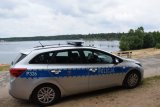 Na zdjęciu widać policyjny radiowóz zaparkowany przed zalewem.