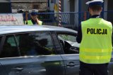 Na zdjęciu widać policjantkę i policjanta kontrolujących kierowcę samochodu zatrzymanego do kontroli drogowej.