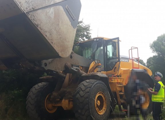 Na zdjęciu widać  policjanta z drogówki stojącego obok ładowarki.