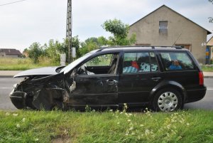 Na zdjęciu widać bok samochodu osobowego. Auto ma pogniecioną blachę i urwane przednie koło.