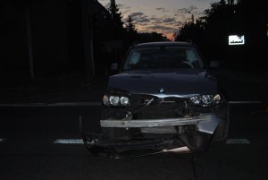 Na zdjęciu widać: samochód osobowy marki BMW. Auto ma zgnieciony przedni zderzak i maskę.