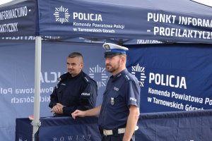 Na zdjęciu widać policjantów stojących przy policyjnym namiocie profilaktycznym
