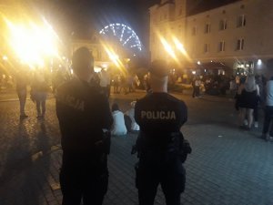 Na zdjęciu widać dwóch policjantów obserwujących uczestników imprezy