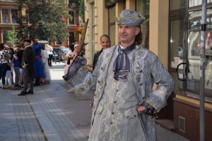 Na zdjęciu widać postać historyczną. Mężczyzna trzyma w dłoni historyczny pistolet