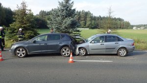 Na zdjęciu dwa samochody osobowe - ford wbity w tył seata. Obok pojazdów stoją strażacy, policjant oraz inne osoby.