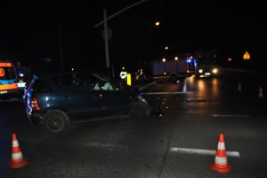 Na zdjęciu widać skrzyżowanie, na którym znajduje się uszkodzony mercedes. W tle zdjęcia widać wóz strażacki oraz karetkę pogotowia.
