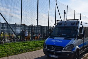 Policyjny radiowóz zaparkowany obok stadionu
