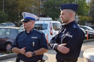 Policjant z prewencji i drogówki obserwujący przemieszczające się osoby