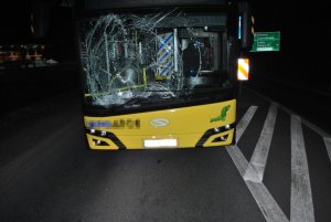 Na zdjęciu widać autobus, który ma rozbitą przednią szybę.