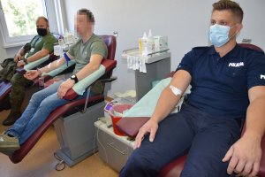 Na fotelach siedzą dwaj policjanci i żołnierz. Mundurowi oddają krew